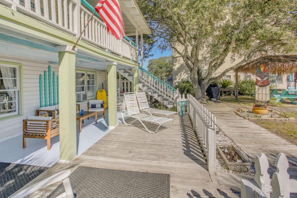 a wooden porch with chairs and an american flag at Coastal Cottage with Ocean View Walk to Pier in Myrtle Beach