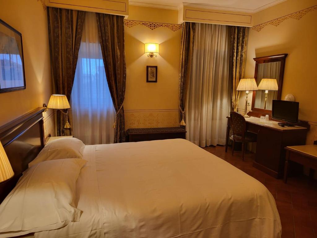 Postel nebo postele na pokoji v ubytování Hotel Logge Dei Mercanti