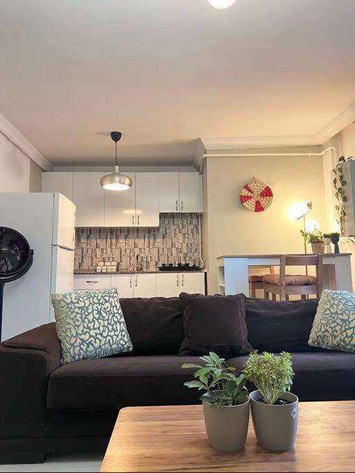 un soggiorno con divano nero e tavolo di Mika Homes a Istanbul