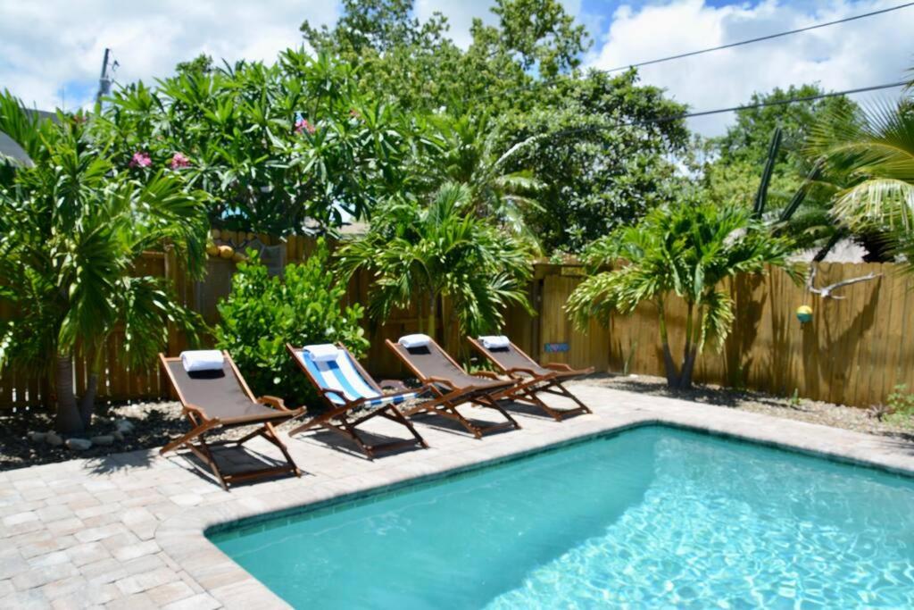 um grupo de espreguiçadeiras e uma piscina em Tropical Retreat Near Beaches, Cruise Terminals em Merritt Island