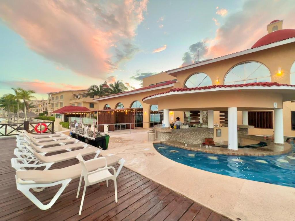 Un complejo con piscina y sillas y un edificio. en All Ritmo by Andiani Travel, en Cancún