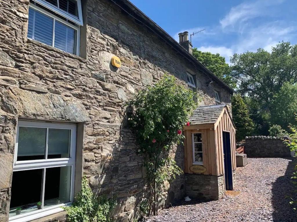 a stone house with a window and a door at Ivy Cottage, Aberfeldy - Highland Perthshire in Aberfeldy