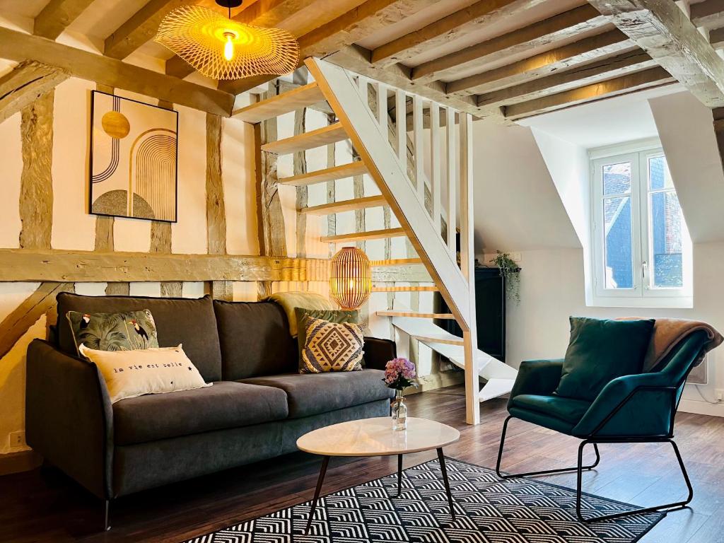 sala de estar con sofá y escalera en Le Perchoir, appartement duplex au cœur d'Honfleur, en Honfleur