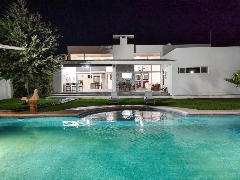 Una gran piscina frente a una casa por la noche. en RESIDENCIA EL ENCINO, en Cuatrociénegas de Carranza