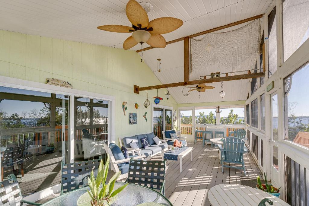 une terrasse couverte avec des chaises et des tables, ainsi qu'un ventilateur de plafond. dans l'établissement Bayfront Placida Paradise with Kayak Walk to Beach!, à Placida