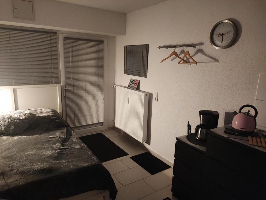 1 dormitorio con 1 cama y reloj en la pared en Appartment zur Ruhe Forsterweg 6, en Hameln