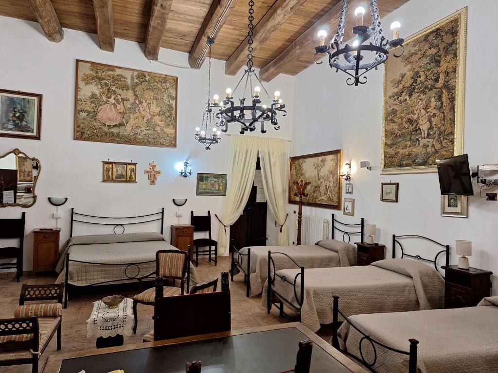 una camera con quattro letti e un lampadario a braccio di il CAPITELLO a Rieti