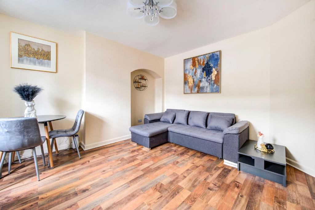 uma sala de estar com um sofá e uma mesa em London serviced apartments BAFOG em Barking