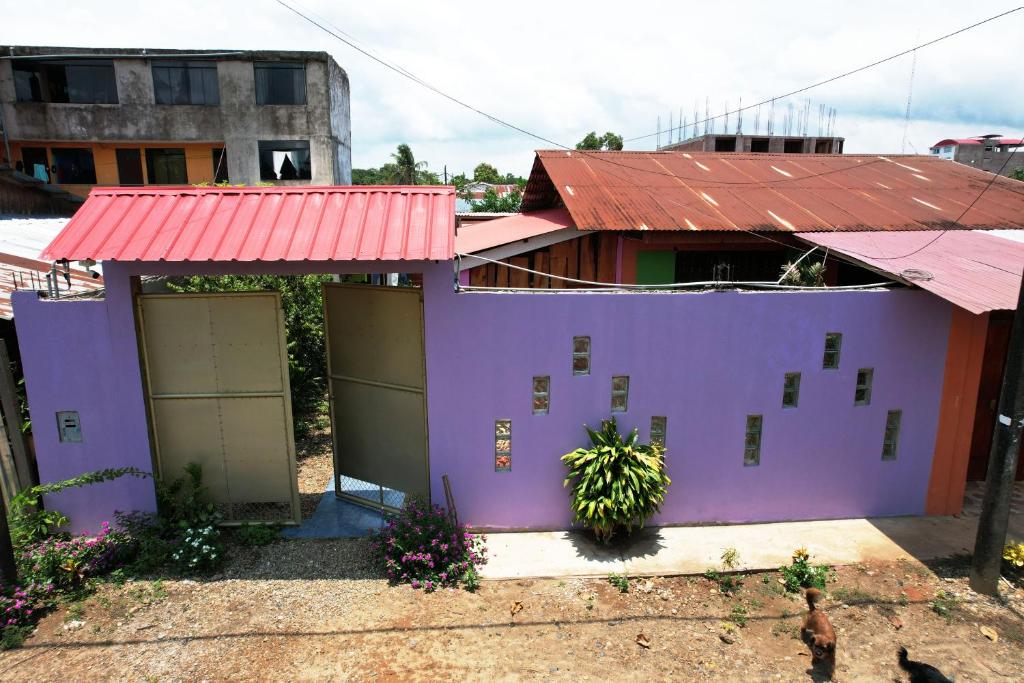 una casa morada con techo rojo en KORYARES HAUS-TAMBOPATA en Puerto Maldonado