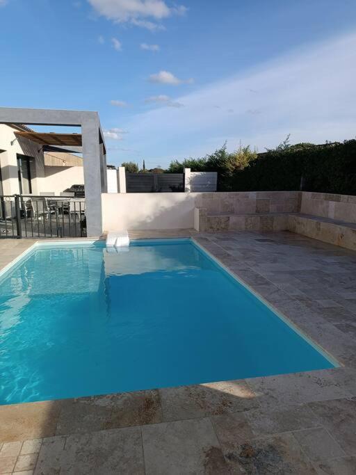 une grande piscine bleue dans une cour arrière dans l'établissement Charmant studio avec piscine, à Villemoustaussou
