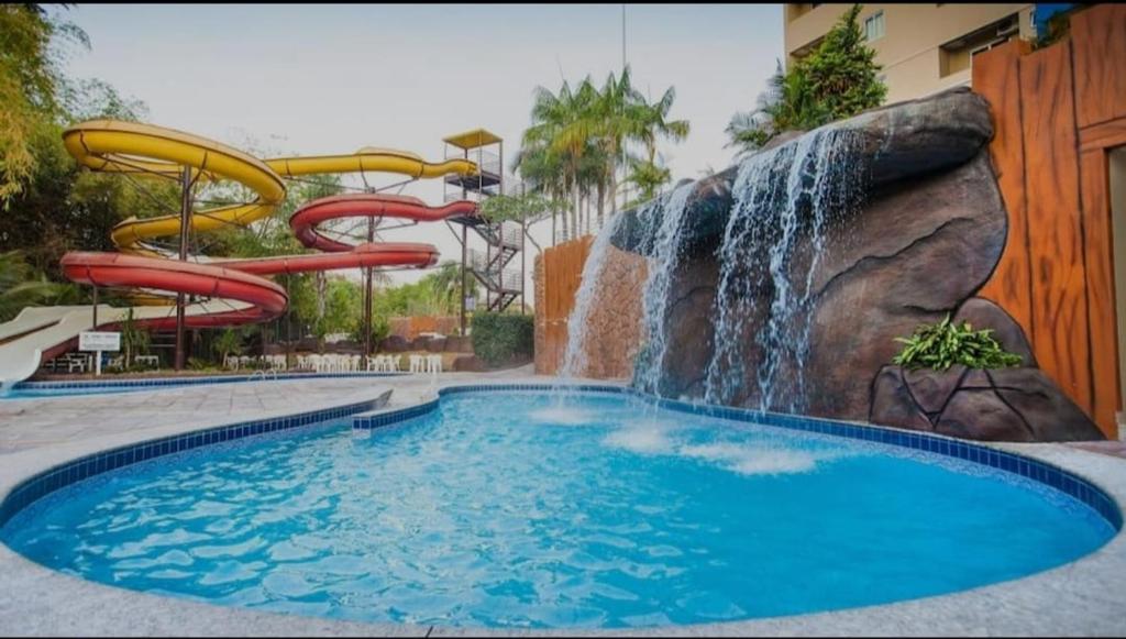 a pool with a water slide and a waterfall at Golden Dolphin Grand Hotel in Caldas Novas