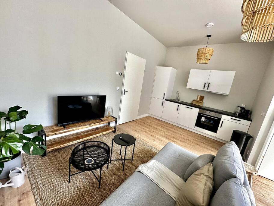 a living room with a gray couch and a kitchen at Aurora 2 bedroom Apartment in Rotterdam