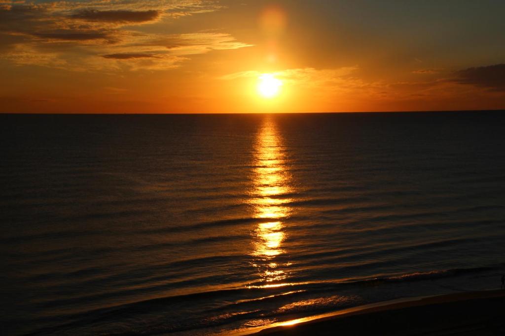 a sunset over the ocean with the sun setting at Apartamento Daimuz in Daimuz