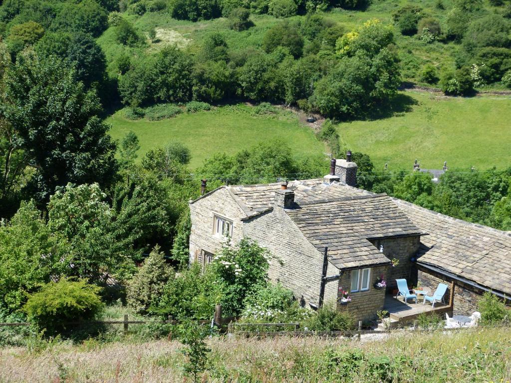 an old house in the middle of a field at Wood End Cottage in Slaithwaite