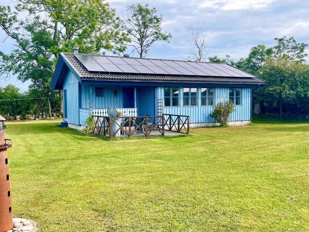シーピンスリーにある6 person holiday home in K PINGSVIKの芝生の庭の青い家