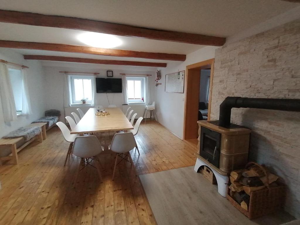 a dining room with a table and a wood stove at Chalupa Krkonoše in Černý Dŭl