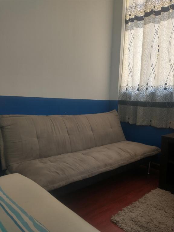 ein Sofa in einem Zimmer mit Fenster in der Unterkunft Hospedaje Akankma in Juliaca