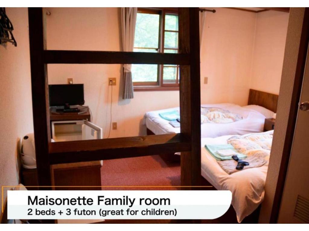 a room with two bunk beds and a mirror at Hotel Montblanc Hakuba - Vacation STAY 97827v in Hakuba