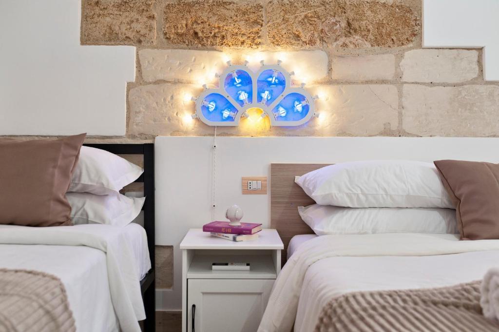 a bedroom with two beds and a blue clock on the wall at Il Cortile dei Cantori in Lecce