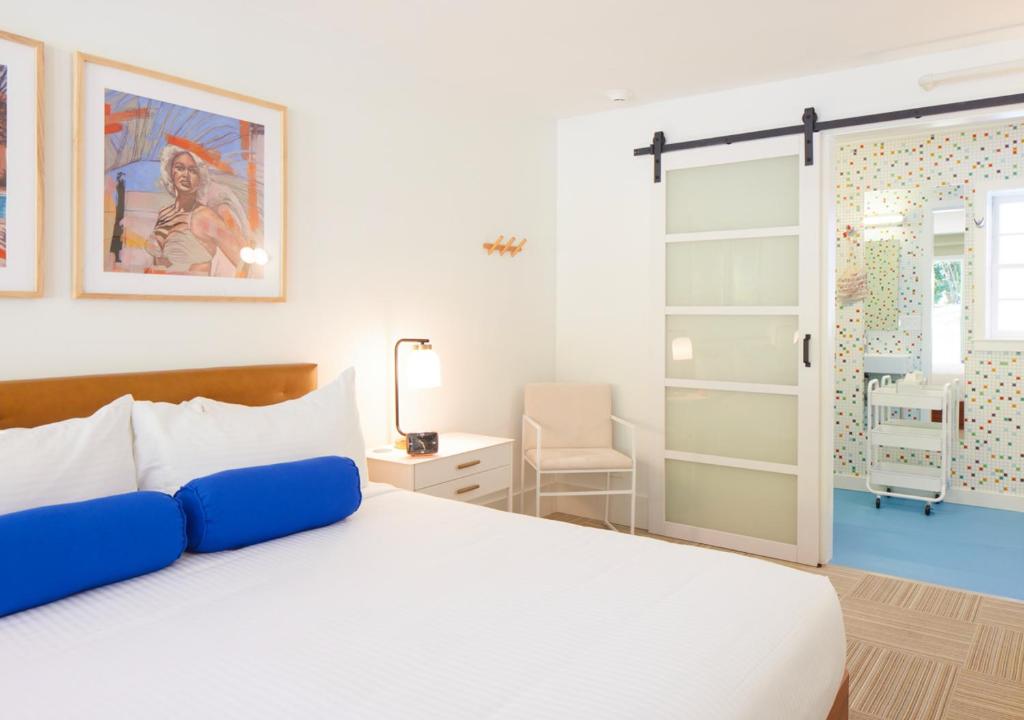 ein Schlafzimmer mit einem weißen Bett und einer Glasschiebetür in der Unterkunft Little Mod in Charlottesville
