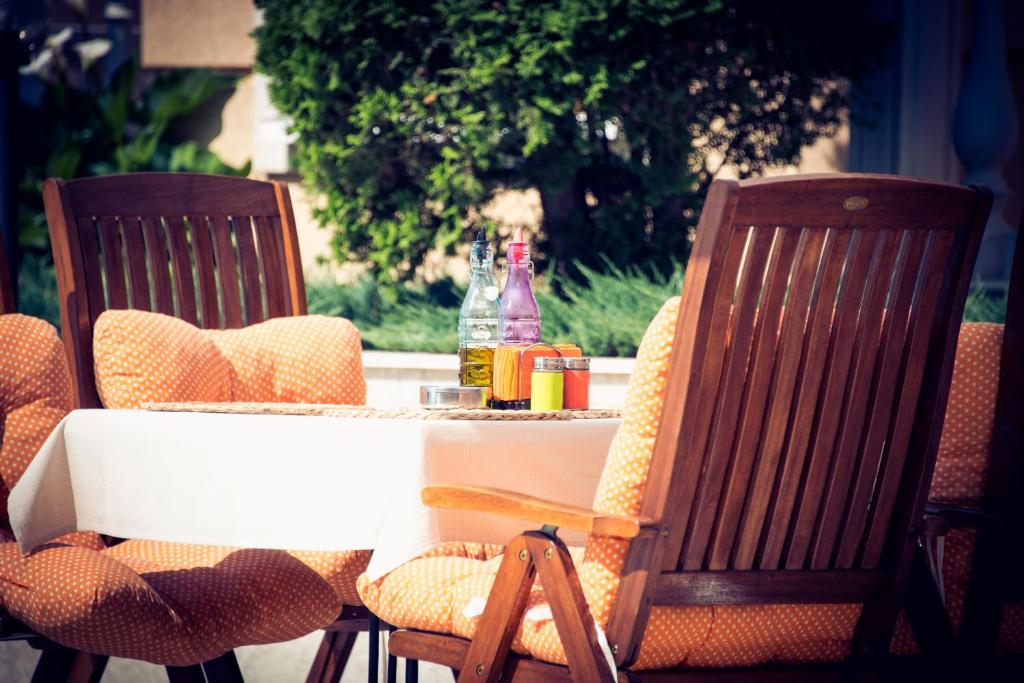an outdoor table with two chairs and a bottle of soda at Apart Hotel Apolonia Palace in Sinemorets