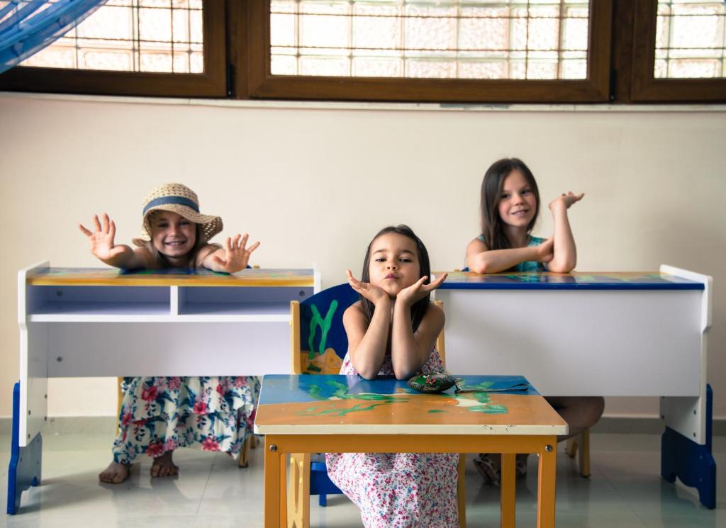 three girls sitting at desks in a classroom at Apart Hotel Apolonia Palace in Sinemorets