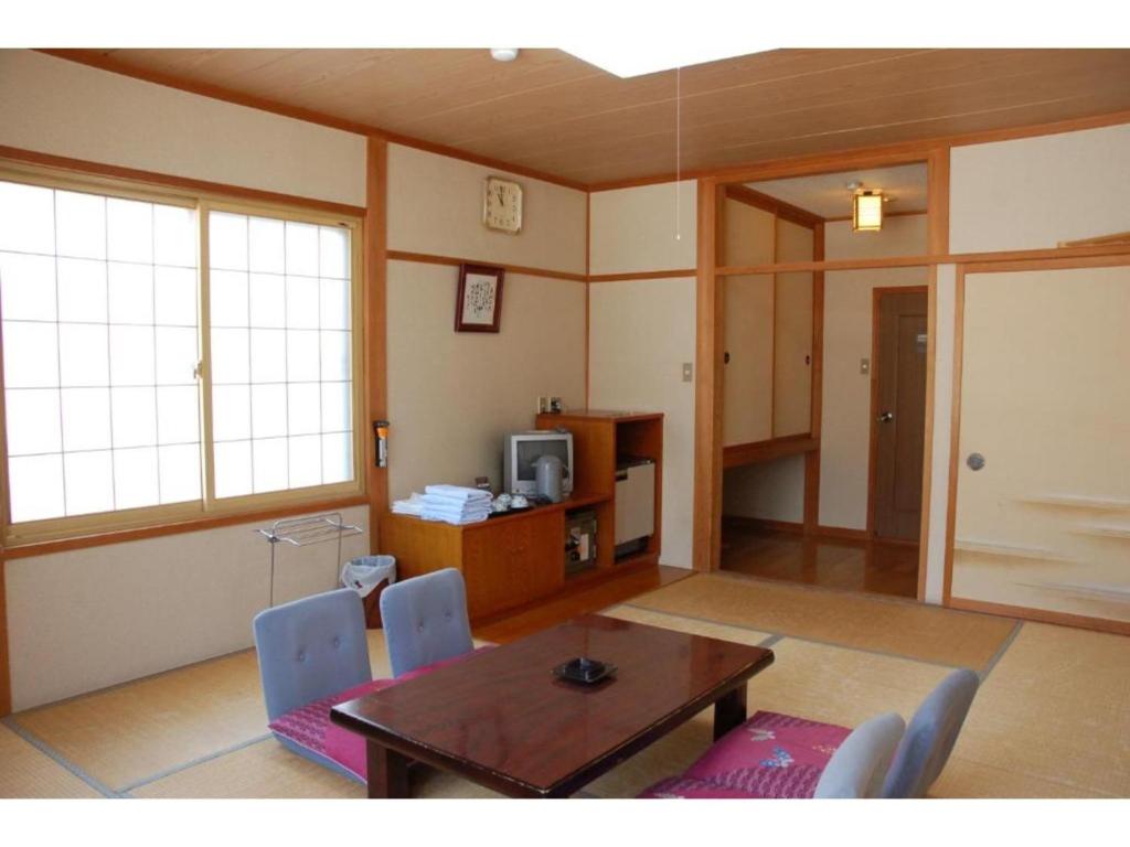 a living room with a wooden table and chairs at Hotel Montblanc Hakuba - Vacation STAY 97813v in Hakuba