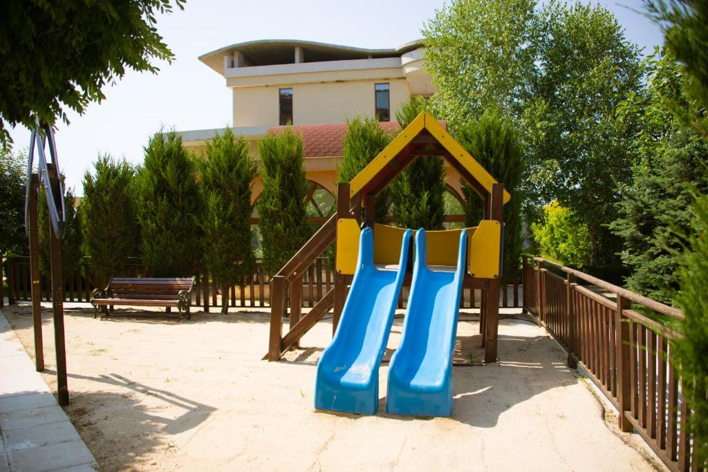 a playground with a slide in a park at Apart Hotel Apolonia Palace in Sinemorets