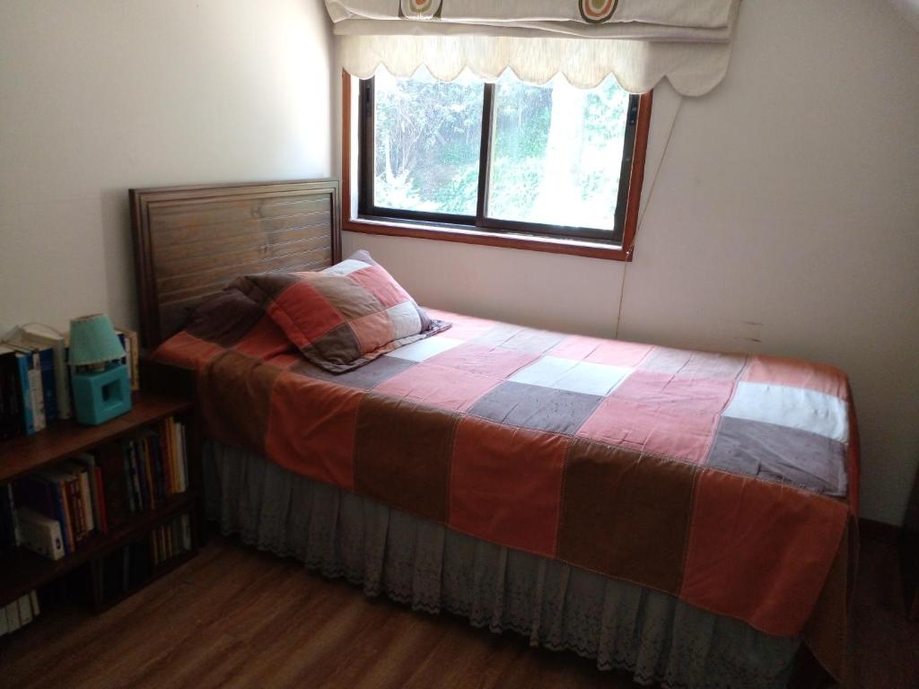 Schlafzimmer mit einem Bett und einem Fenster in der Unterkunft Acogedora Habitación in Santiago
