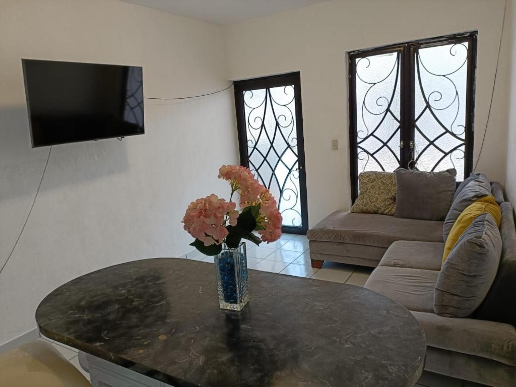 a living room with a table with a vase of flowers on it at EL SOLAR in Guanajuato