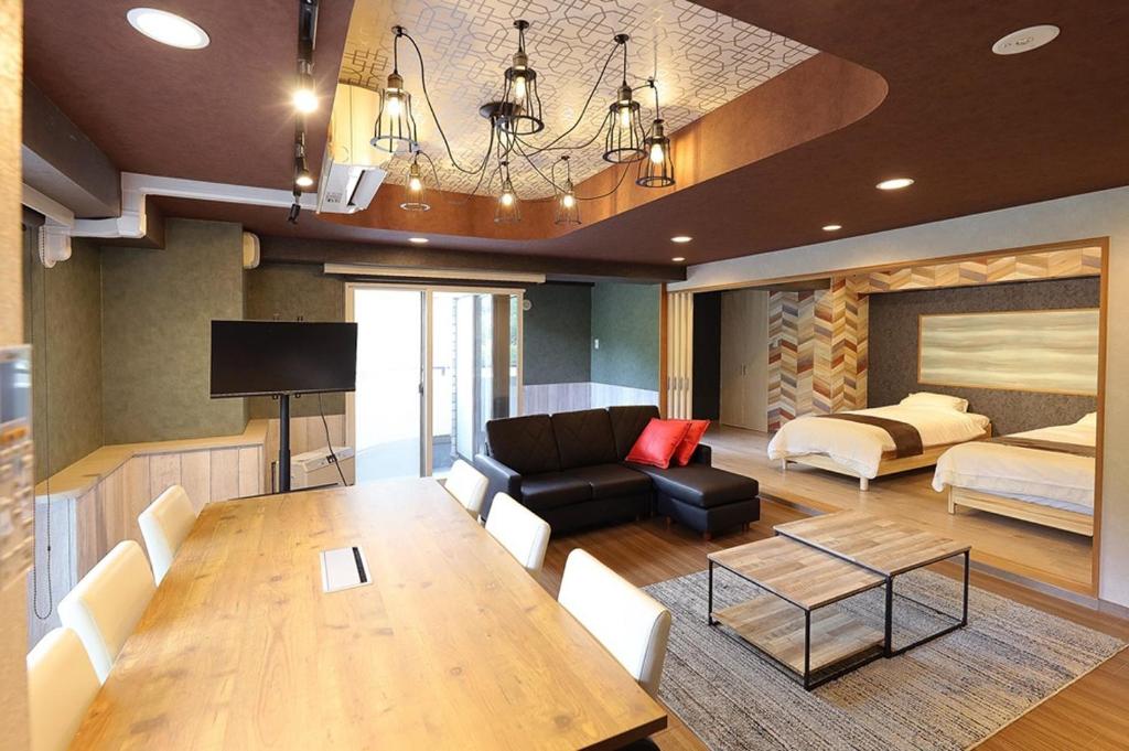 ein Wohnzimmer mit einem Tisch, einem Sofa und einem Bett in der Unterkunft Lions Mansion Sapporo Jozankei Sanbankan Room 201 - Vacation STAY 14335 in Jozankei