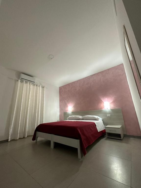 una camera con un letto con una coperta rossa di A Due Passi dal Mare a Catanzaro