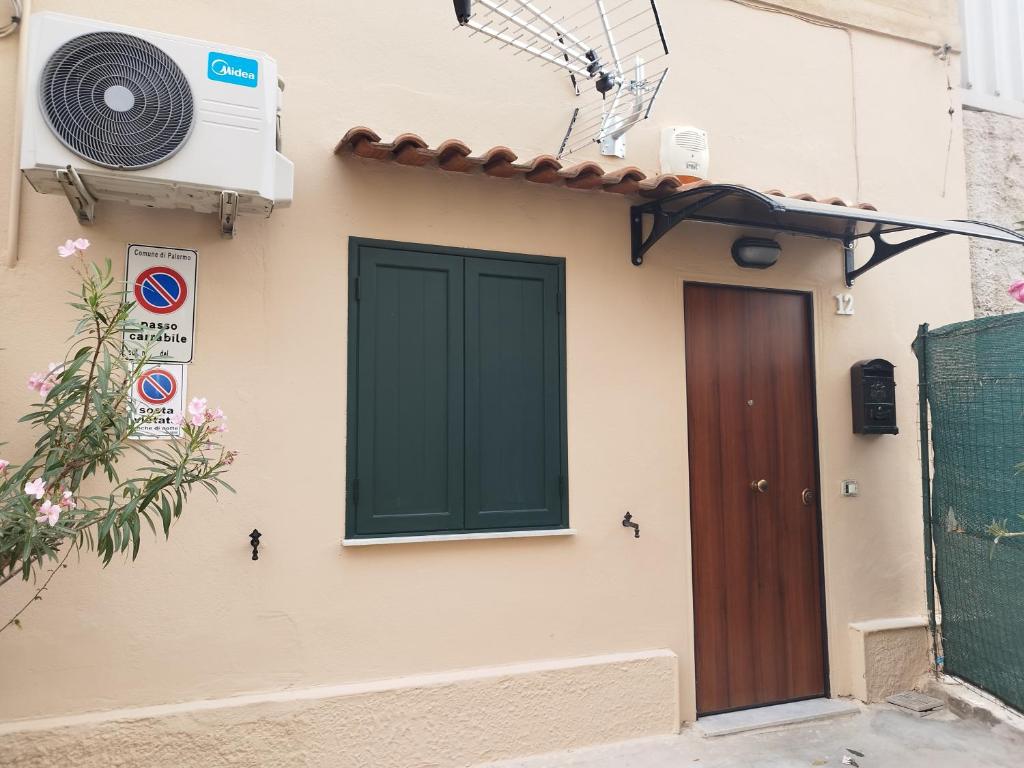 una casa con una porta verde e un ventilatore di Casetta Malfitano a Palermo