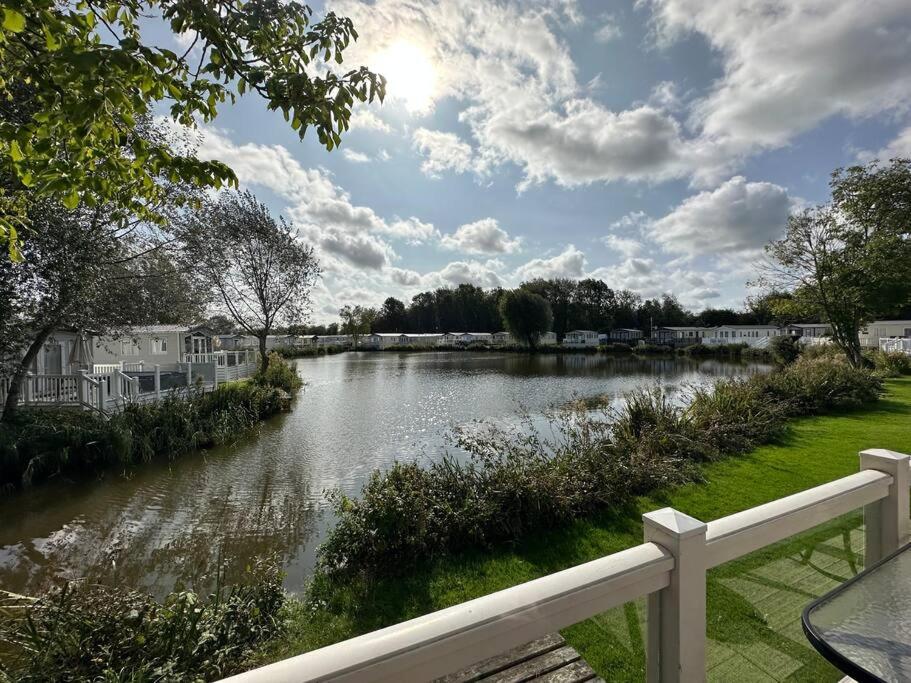 a view of a river with a white fence at Waters Edge, Hoburne Cotswolds in South Cerney