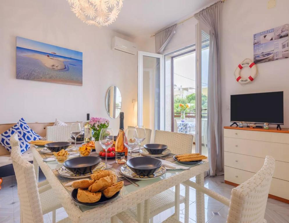 a dining room with a table and chairs and a television at Relais Torre Chianca With Climate, Parking, Wi-Fi Panoramic Rooftop in Porto Cesareo