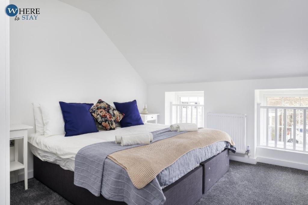 um quarto branco com uma cama grande e almofadas azuis em Bright 2bed Apartment in Worksop em Worksop