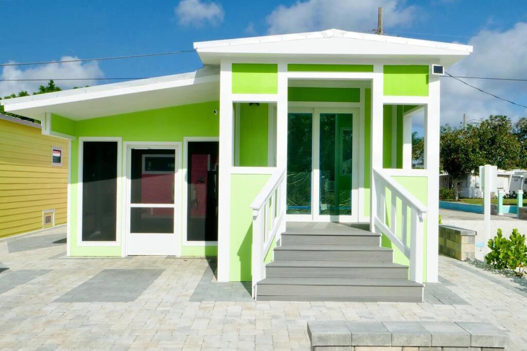 een klein groen en wit huis met een veranda bij Key Lime Tiny Home New&Cozy in Sarasota