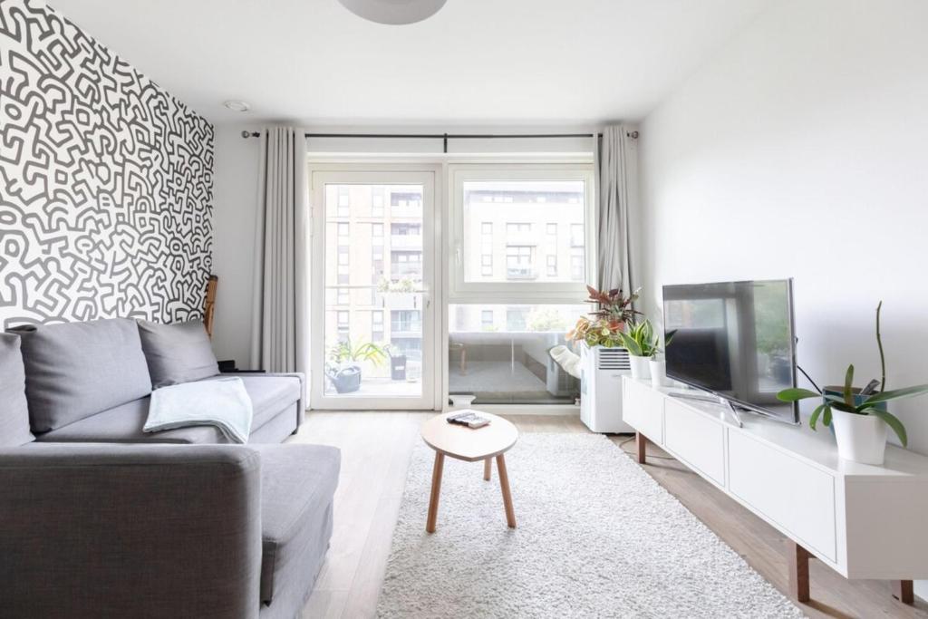 a living room with a couch and a tv at Stunning 1bedroom Flat wBalcony - Surrey Quays! in London