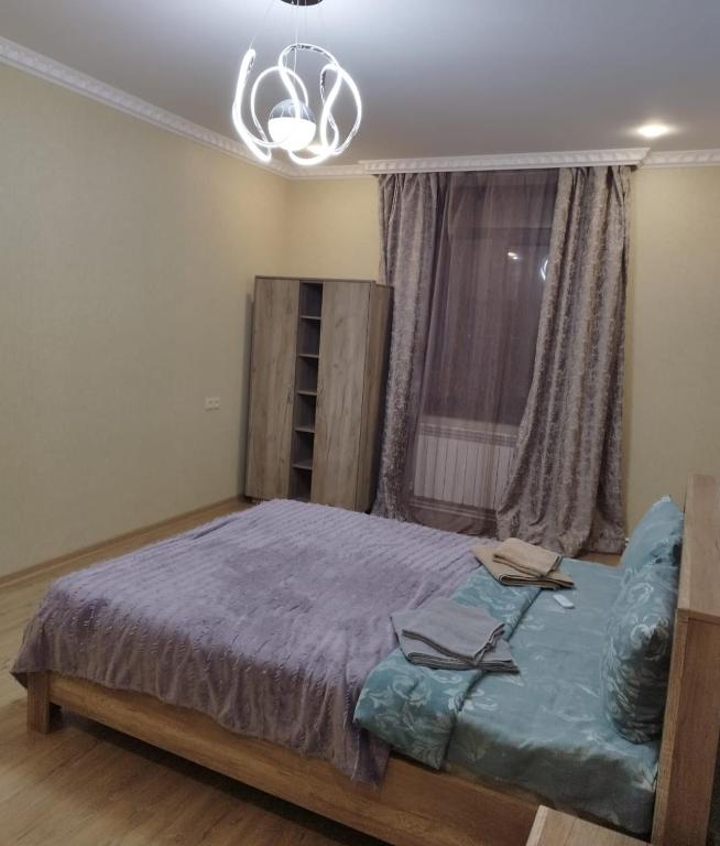 um quarto com uma cama grande e uma janela em Квартира в центре города Ванадзор em Vanadzor