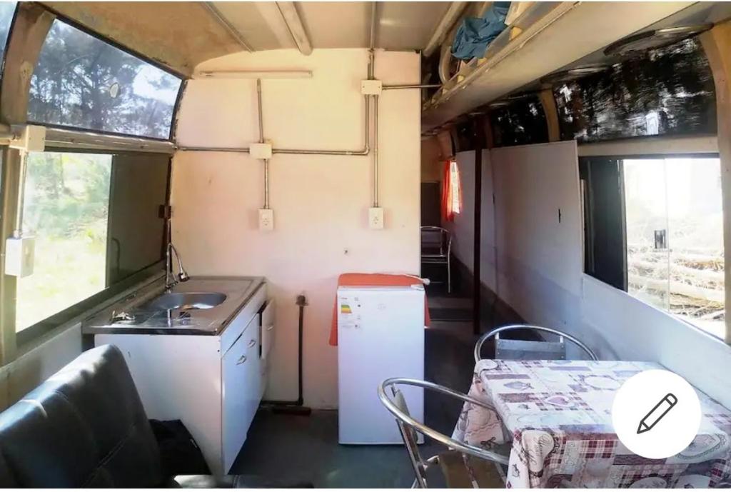 una cocina con fregadero y una mesa en un remolque en my bus, en Punta del Diablo