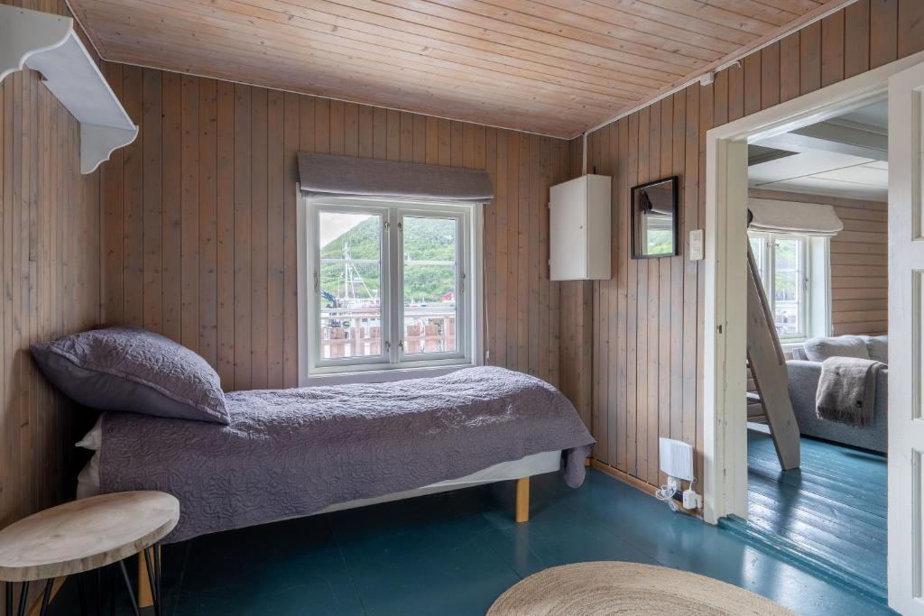 a bedroom with a bed and a window at Vesterålen Rorbuer in Bø i Vesterålen