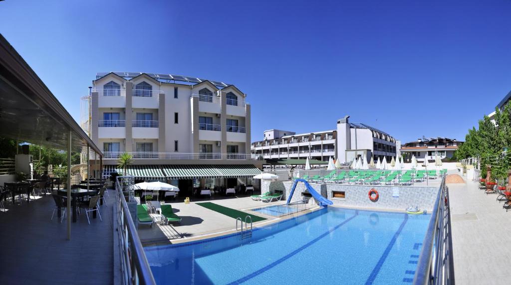 a swimming pool with a slide in front of a building at Erkal Resort Hotel in Kemer