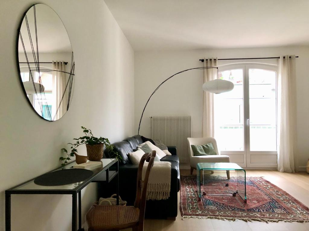 sala de estar con sofá y espejo en Appartement Coeur de Ville Cathédrale - Ascenseur -, en Colmar
