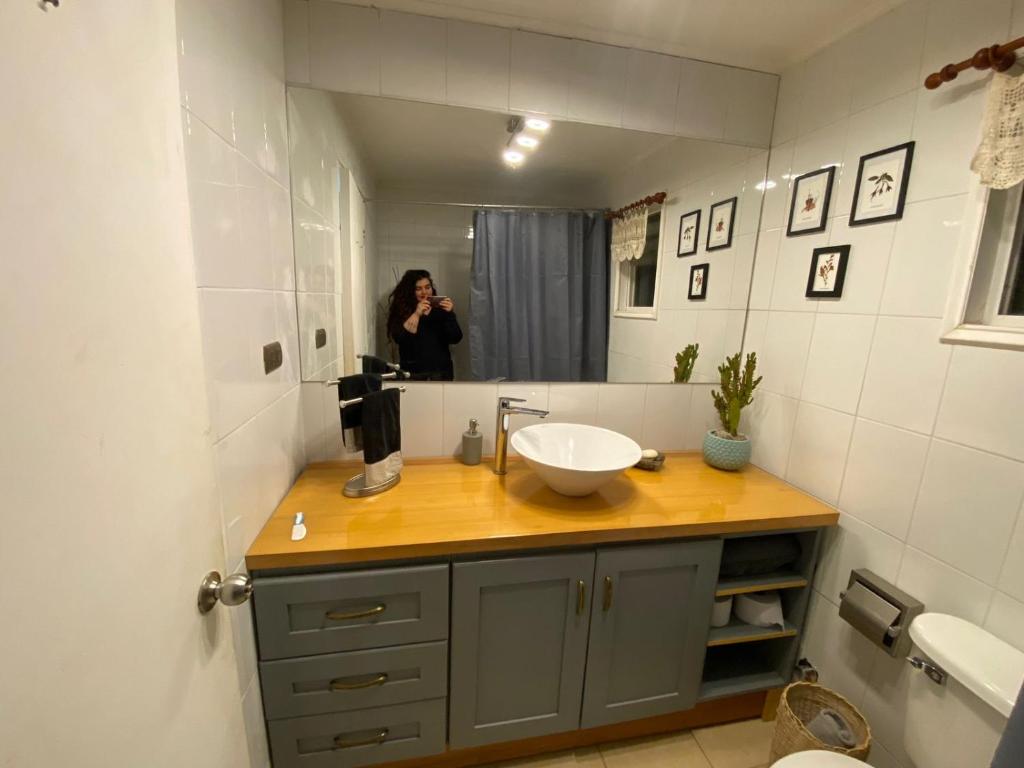une femme prenant une photo dans un miroir de salle de bains dans l'établissement Hermosa Casa en buen barrio residencial, à Castro