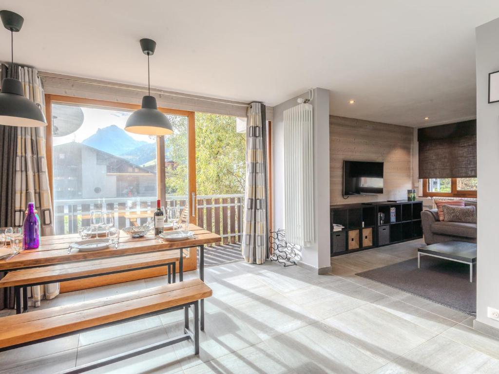 un salon avec une grande fenêtre et une table dans l'établissement Appartement rénové 3 pièces avec balcons, proche pistes et centre de Morzine - FR-1-754-68, à Morzine