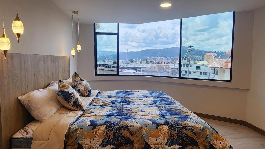a bedroom with a bed and a large window at 302 Departamento La Terraza in Cuenca