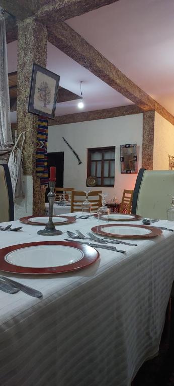 uma mesa com uma toalha de mesa branca e vermelha em Riad dar idsalah em Ouirgane