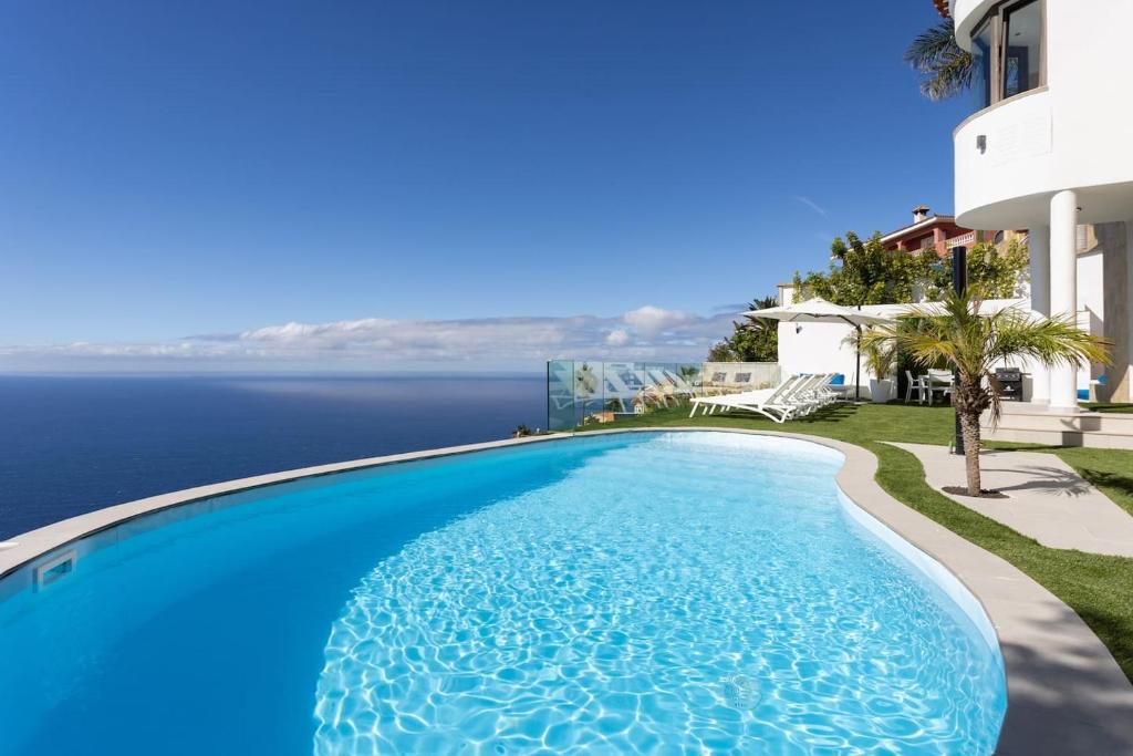 a swimming pool with a view of the ocean at Villa Canela in Sauzal