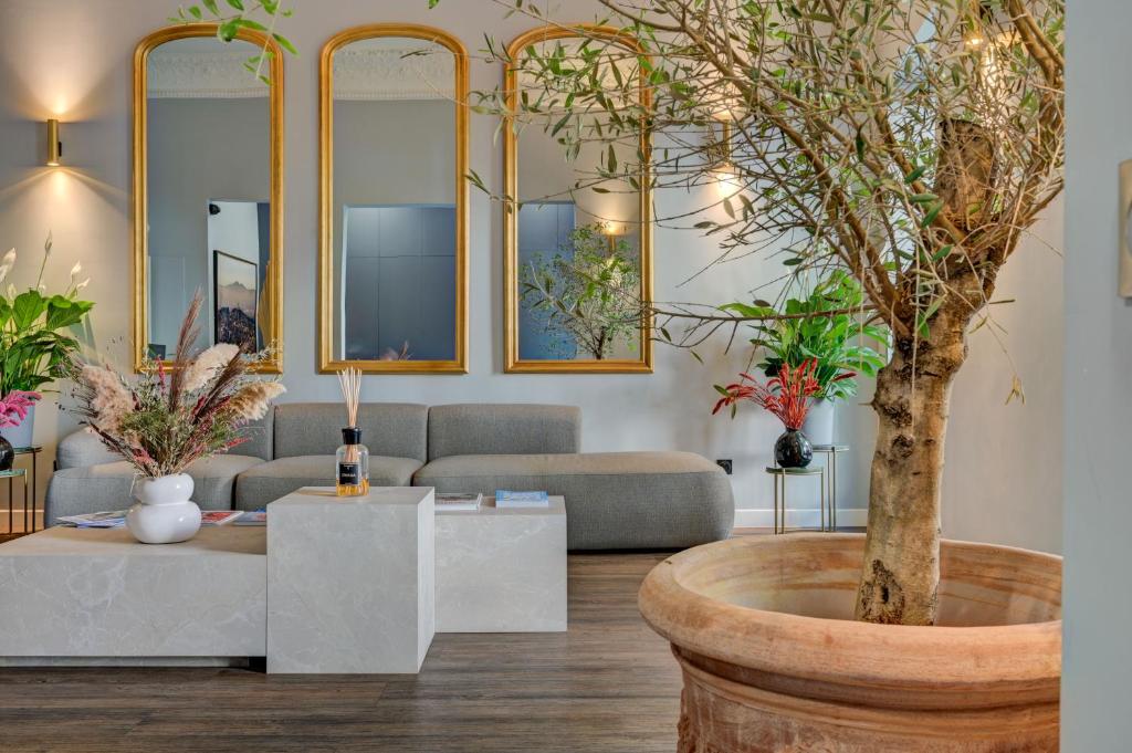 a living room with a tree in a large pot at Boutique Hôtel Provencia in Marseille