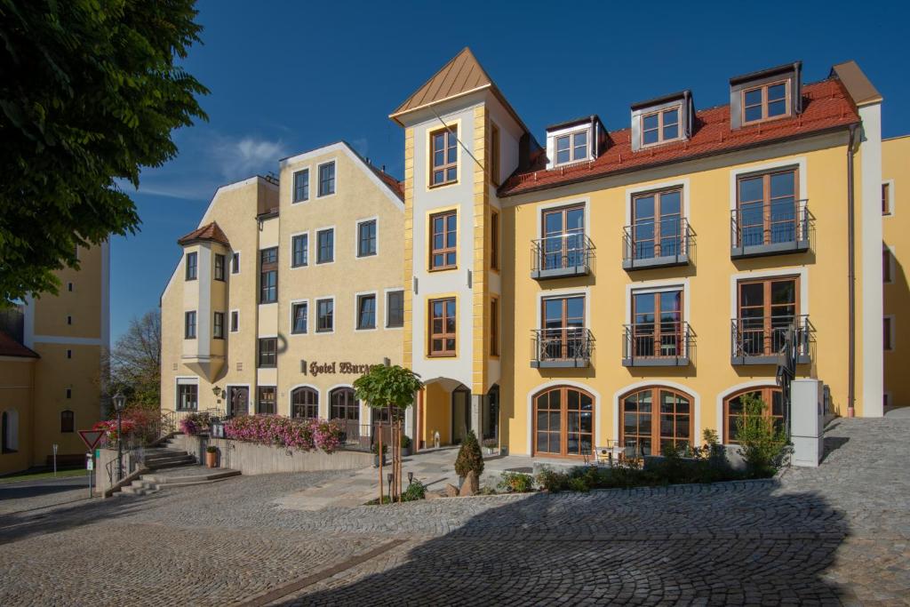 a row of yellow buildings on a cobblestone street at Hotel Wurzer in Tännesberg